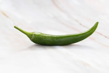 Closeup of a fresh jalapeno pepper on a white table