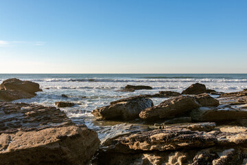 Fototapeta na wymiar Trebarwith Strand Beach at low tide looking out to sea between rocks