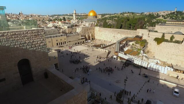  Jewish shrine of the Wailing Wall in the old city of Jerusalem against the backdrop of the Al-Aqsa Mosque and many people. Top view of the historic city center of Jerusalem. High quality 4k footage