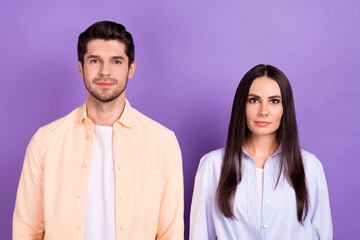 Portrait of two concentrated focused people calm face isolated on pastel purple color background