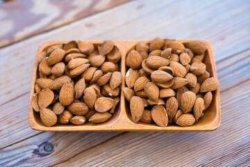 Almonds in a wooden bowl on an old wooden table