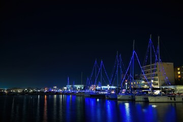 Fototapeta na wymiar Harbor full of boats near the buildings at night time