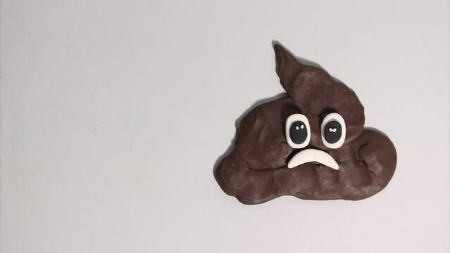 Plasticine stop motion animation, funny poop feces with eyes and mouth talking and smiling. Symbol of dirty smelly deeds and total bad luck. Humorous sign of toilet and bad smell.