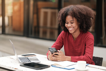 American African Woman working with computer phone and Tablet outdoor.