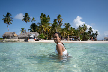 Beautiful tan Colombian women in crystal Caribbean sea water in San Blas Palm tree Islands, Panama