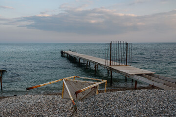 Wooden pier with closed iron gates in blue sea. Koktebel. Crimea