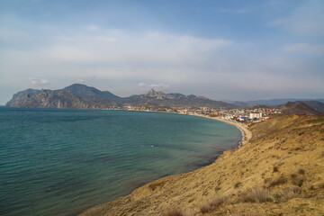 View of seaside resort city Koktebel , mountain Kara Dag from hill in spring. Crimea
