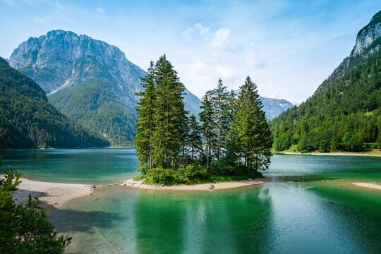 Breathtaking view of lush trees and emerald-green waters in Lago del Predil near Tarvisio in Italy