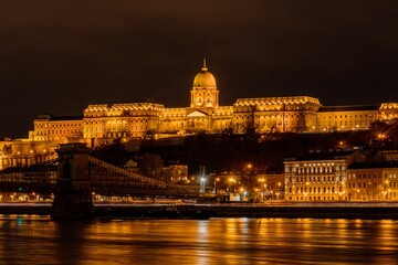 Fototapeta na wymiar Illuminated Buda castle at night above the Danube river in Budapest, Hungary