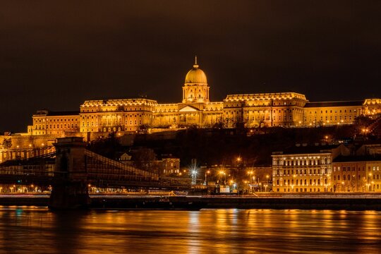 Illuminated Buda castle at night above the Danube river in Budapest, Hungary