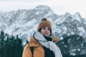 Portrait of a female standing in front of snow-capped Mount Mangart in Julian alps