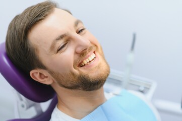 Dental care concept. Handsome young guy at the dentist's office.