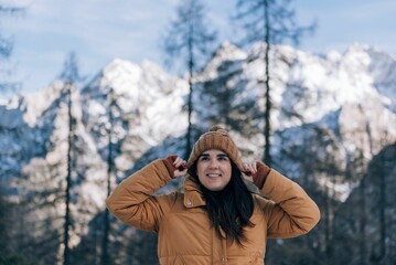 Fototapeta na wymiar Caucasian female wearing brown coat and hat in the snowy mountains