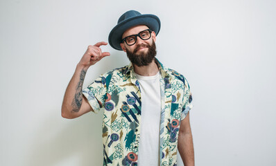 Some more, please. A cute hipster guy in a hat, with a beard gesticulates with his fingers, shows...