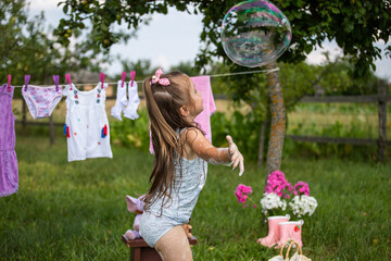 Fun kid fun. Washing in the fresh air. A child is playing in the garden. Little hostess. A little...