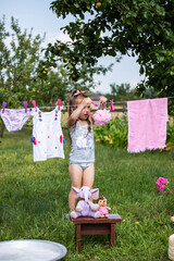 Fun kid fun. Washing in the fresh air. A child is playing in the garden. Little hostess. A little...