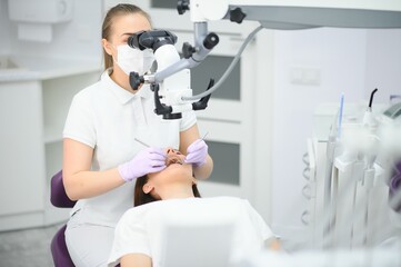 professional dentist examination patient with microscope at the office