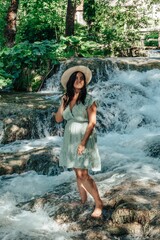 Portrait of happy young woman in front of stream with cascades