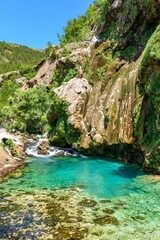 Fototapeta na wymiar Beautiful creek and turquoise natural pool under rocky cliff at Krcic waterfall near Knin, Croatia