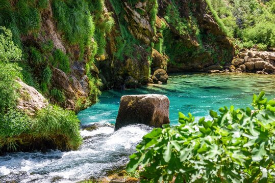 Beautiful creek and turquoise natural pool under rocky cliff at Krcic waterfall near Knin, Croatia
