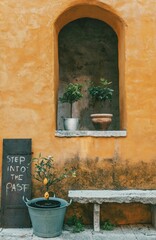 Orange ancient building with potted plants on stone window sill