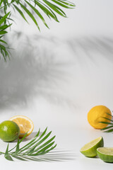 White background with palm leaves, lemon and lime slices. Modern product display for advertising...