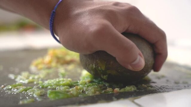 making Bolivian llajua with round batan in slow motion