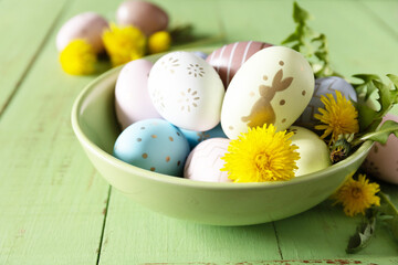 Obraz na płótnie Canvas Happy Easter Holidays. Handmade Easter colorful eggs and spring flowers dandelions on a rustic wooden table. Easter composition. Copy space.