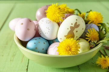 Obraz na płótnie Canvas Happy Easter Holidays. Handmade Easter colorful eggs and spring flowers dandelions on a rustic wooden table. Easter composition.
