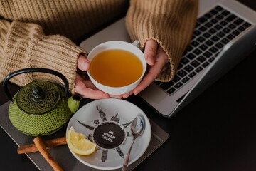 Close-up shot of female hands holding her teacup in a cafe