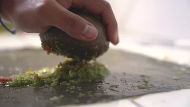 making Bolivian llajua with round batan in slow motion