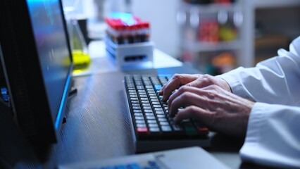 Genetic laboratory researcher inserting DNA study results in computer, science