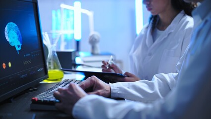 Doctors examining brain image on computer, disease diagnostics and treatment