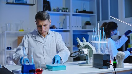 Forensic lab technicians analyzing crime scene samples, checking patterns under microscope