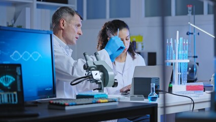Clinical laboratory scientists studying biological material sample, diagnostics
