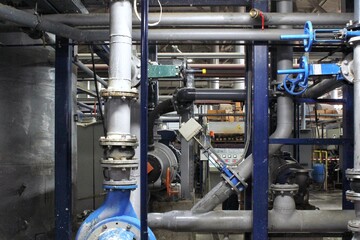 Steel pipes, tubes, steam turbine, valves, machinery, cables of modern factory. Gas boiler room...