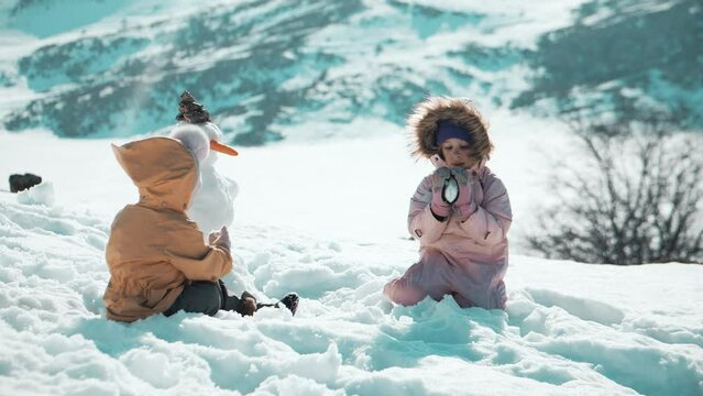 Little girls play in snow in winter