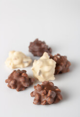sweets with nuts in white and brown chocolate, selective focus, copy space