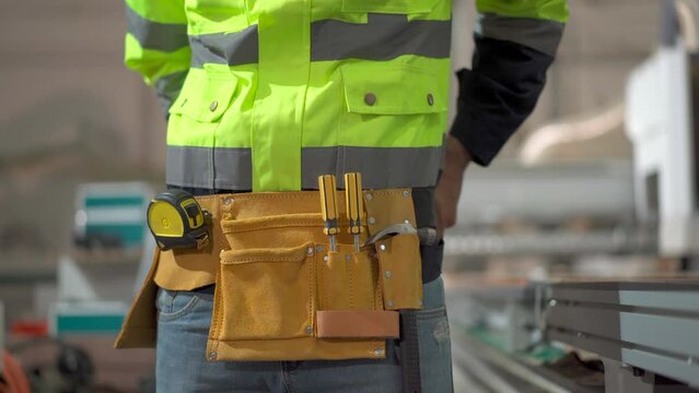 Professional factory engineer get dressed with an equipments or tools before getting to work. Mechanical engineer attach a tools pouch.