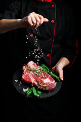 Beef steak and salt by chef on the background with free space for text design or logotype menu restaurant. Meat. On a black background.