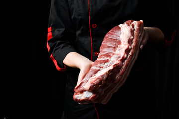 Meat. The chef is holding a piece of pork bacon. Meat preparation. Front view.