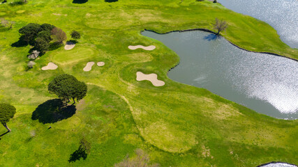 Aerial perpendicular view of an empty golf course with many lakes and ponds. There is no one in the sports club. Sports concept.