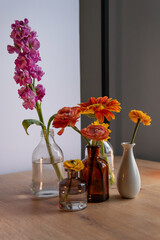 simple composition with flowers for banner and postcard. beautiful flowers in different vases on a light background.