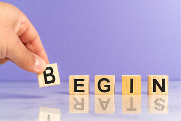 Hand placing wooden cubes with the word begin and start as a reflection. Professional growth mindset. High quality photo