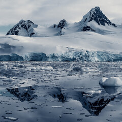 Fototapeta na wymiar Snow Glacier Covered Mountains Reflecting in the Still Arctic Water of Antarctica, Square Shot