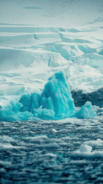 Glacier and Very Blue Iceberg, Floating in Antarctica, Vertical Image