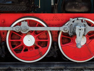 two large red metal wheels of an old train