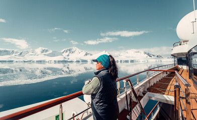 Female Tourist On Huge Luxury Antarctica Cruise Ship Looking Out At The Stunning Scenic Arctic Landscape,  - obrazy, fototapety, plakaty