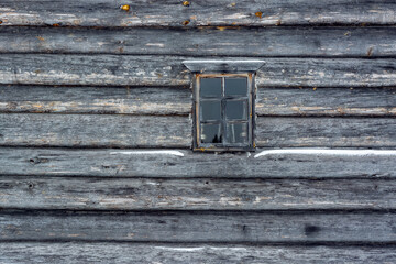 Small rectangular window against a wall of old, grayed logs. From the Window of the World series.