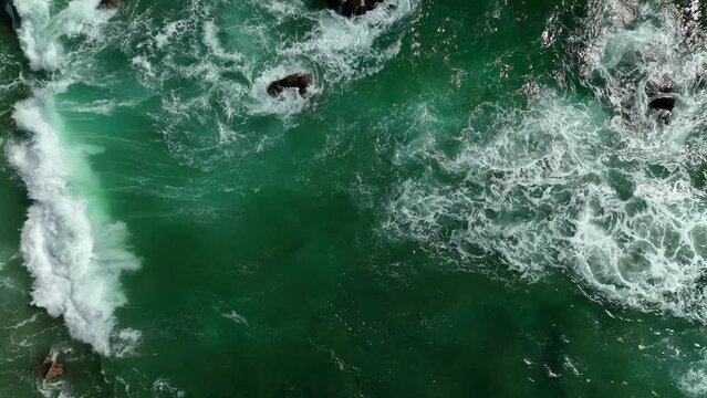 Tropical waves crashing on shore onto the beach. turqoise blue and sunny day aerial view of ocean waves 4k drone.